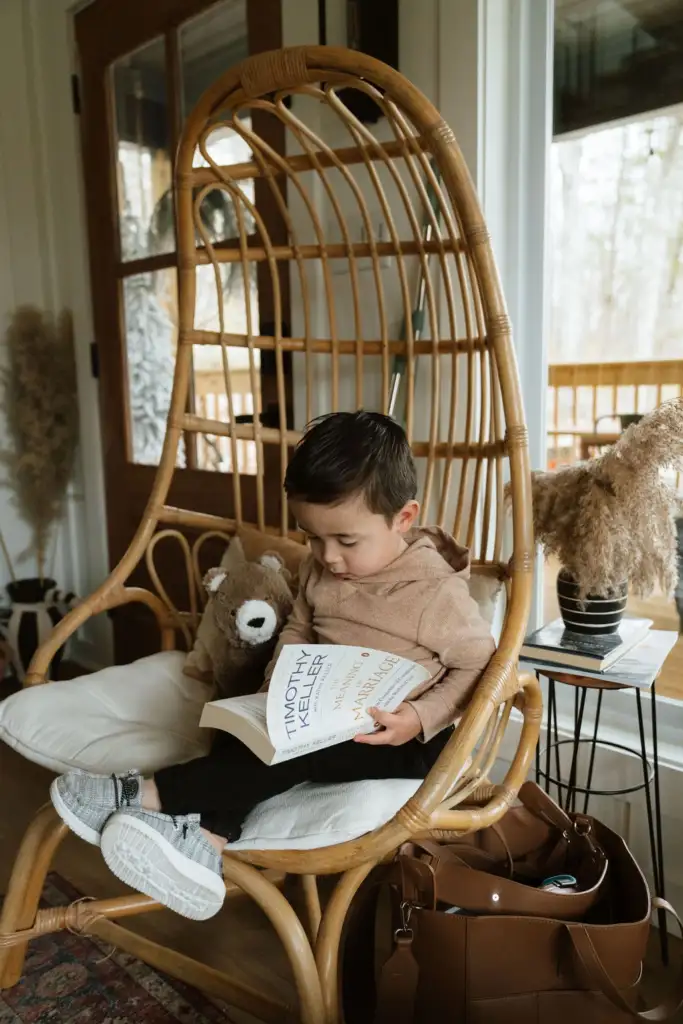 William Chong, from Appmanda.com, reads in a wicker chair with his teddy bear.