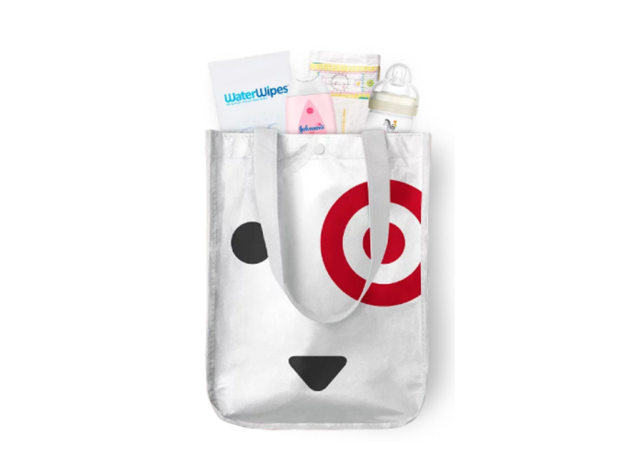 Target baby welcome box kit - image of a small Target reusable bag featuring their dog mascot. Showing out of the top of the bag are an assortment of baby samples.
